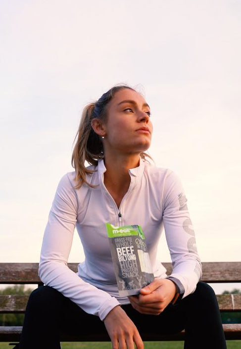 Athlete sitting on a bench with a packet of biltong